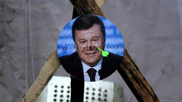Demonstranti na kyjevskm Majdanu si z portrtu sesazenho prezidenta Viktora Janukovye udlali ter na ipky (24. nora 2014).