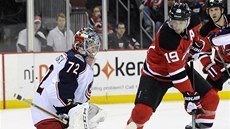 LIÁK.  Travis Zajac  Z New Jersey zkouí pelstít brankáe Columbusu. Sergej