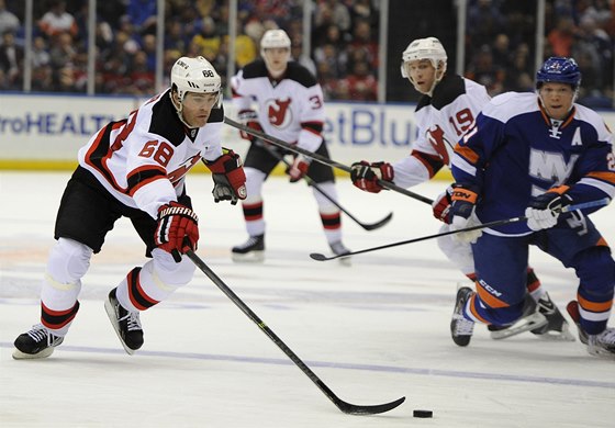 Jaromír Jágr se ene za pukem v utkání s NY Islanders. Jeho akci sleduje Kyle