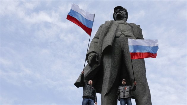 Protestující v Doncku mávají ruskými vlajkami ped gigantickou sochou...