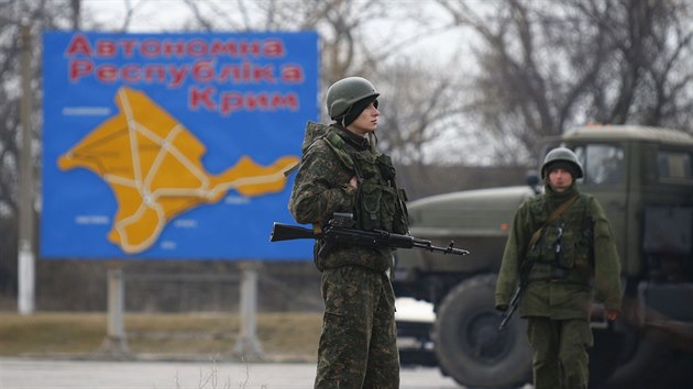 Rut vojci hldkuj nedaleko krymskho Kere. V pozad je mapa krymskho regionu. (4. bezna 2014)