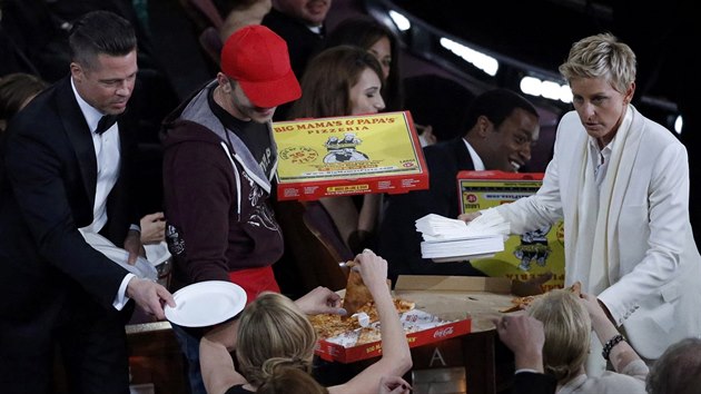 Modertorka veera Ellen DeGeneres rozn hostm pizzu, Brad Pitt podv tale. (2. bezna 2014)