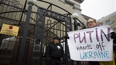 ena s transparentem "Putine ruce pry od Ukrajiny" bhem protestu ped ruskou