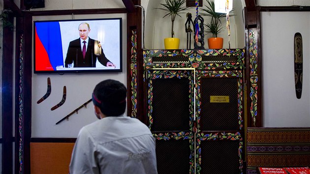 Kucha ze Simferopolu sleduje vystoupen Vladimira Putina ped ruskmi poslanci (18. bezna 2014)