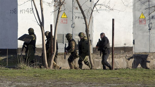 Rut ozbrojenci prohledvaj okol ukrajinsk zkladny v Simferopolu. Pi tern pestelce zde zahynuli dva lid.  (18. bezna 2014)