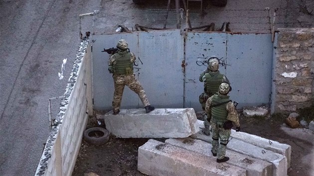 Rut ozbrojenci prohledvaj okol ukrajinsk zkladny v Simferopolu. Pi tern pestelce zde zahynuli dva lid.  (18. bezna 2014)