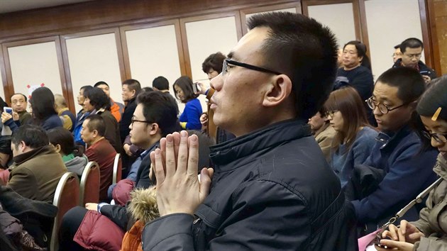 Pbuzn jednoho z cestujcch letu MH370 se modl pi tiskov konferenci v pekingskm hotelu Lido. (10. bezna 2014)