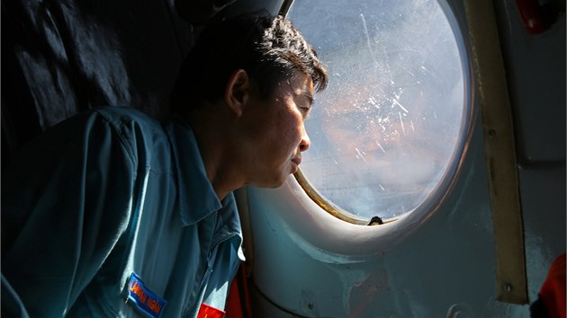 Dstojnk vietnamskho nmonictva sleduje moskou hladinu mezi Vietnamem a Malajsi. Z paluby letounu sovtsk vroby ptr po troskch zmizelho letadla. (14. bezna 2014)