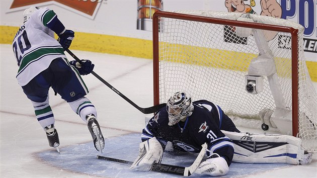 Ondej Pavelec z Winnipegu nestail na njezd vancouverskho Chrise Higginse.