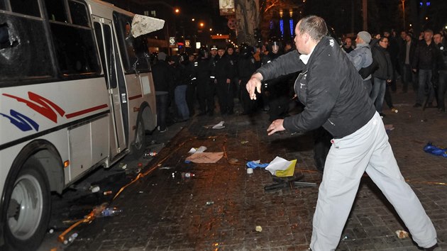 Prorusk aktivista met kameny po policejnm autobusu a proukrajinskmi demonstranty (Donck, 13. bezna 2014).