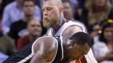 Vousatý obr Chris Andersen z Miami zastavuje Andraye Blatche z Brooklynu.