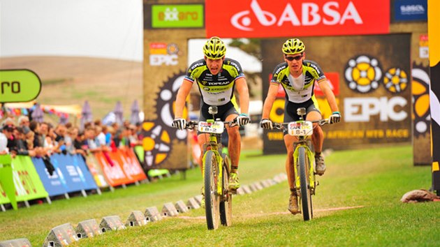 Biker Kristin Hynek (vlevo) se svm kolegou Robertem Mennenem v cli etapy Cape Epic.