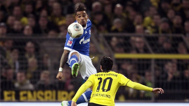 VE VSKOKU. Kevin-Prince Boateng ze Schalke zpracovv m, sleduje ho Henrich Mchitarjan z Dortmundu. 