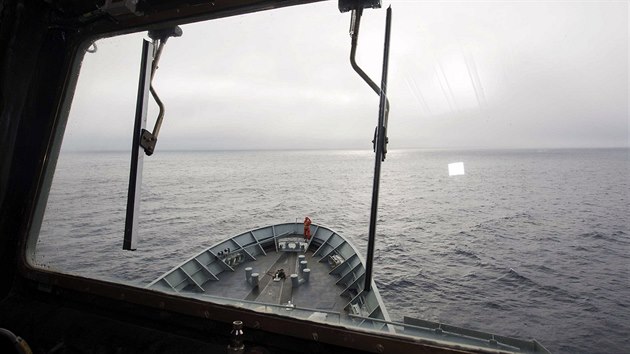 Satelity zachytily trosky v jin sti Indickho ocenu, ale lod zatm na dn nenarazily. Australsk nmonk s dalekohledem stoj na pdi nmon lodi HMAS Success (28.bezna 2014).