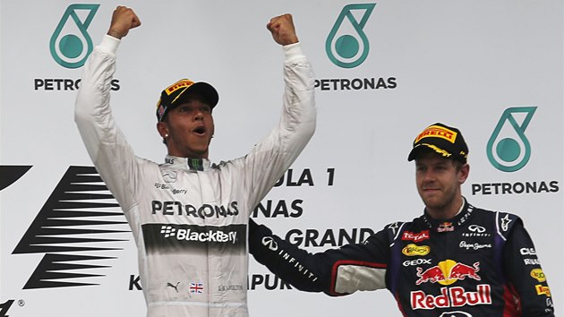 UZNAL POPLCN. Rozzen Lewis Hamilton zved ruce po triumfu ve Vek cen Malajsie, poplcv ho adujc ampion Sebastian Vettel.