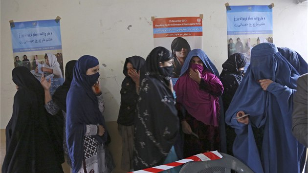 Skupina Afghnek ek ve front na pleitost podlet se na vbru novho prezidenta. Tamn zdi zdob plakty, kter lkaj eny k volebnm urnm. (5. dubna 2014)