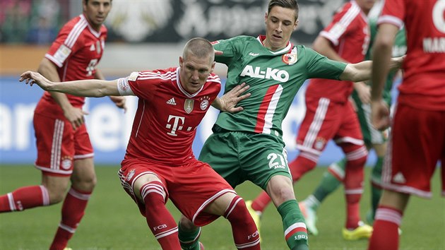 NEPUSTM T. Bastian Schweinsteiger z Bayernu Mnichov (vlevo) odmt pepustit baln Dominikovi Kohrovi z Augsburgu.