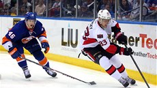 Matt Donovan z NY Islanders sleduje kouzla Alee Hemského z Ottawy.