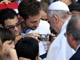 Lidé ukazují papei Frantikovi snímky na mobilních telefonech pi jeho...