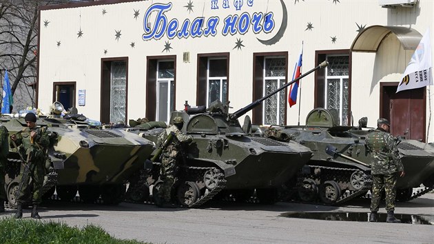 Neoznaen ozbrojenci v centru Slavjansku. Na jejich transportrech je vidt rusk vlajka a vlajka tzv. Donck lidov republiky (16. dubna 2014)