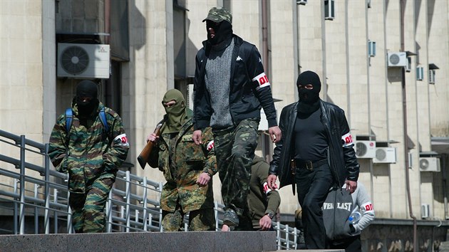 Donckou radnici obsadili prorut ozbrojenci. Na pskch na rukvu maj napsno OPLOT (esky Pevnost), co je podle nich slovansk vlasteneck organizace. (16. dubna 2014)