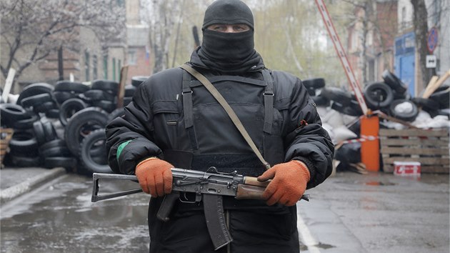 Prorusk ozbrojenec stoj na stri ped obsazenou policejn stanic ve vchodoukrajinskm Charkov (13. 4. 2014).