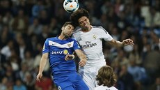 V hlavikovém souboji bojuje o mí Pepe z Realu Madrid (vpravo) a Rodrigo Rios...