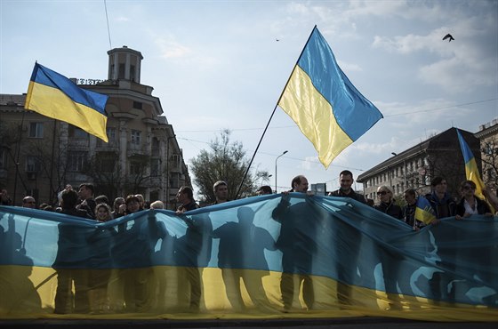 Stoupenci nové kyjevské vlády drí obí ukrajinskou vlajku na shromádní v...