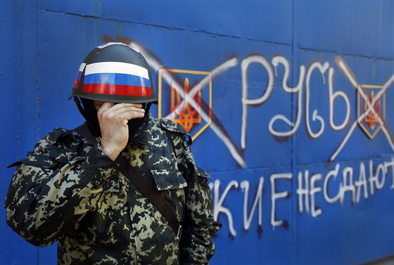 Proruský ozbrojenec z výchoukrajinského Slavjansku si nasazuje helmu....
