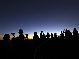 SILUETY. Turisté ekají na východ slunce u Ayers Rock v Austrálii. Obí...