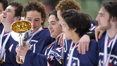 Amerití hokejisté se zlatými medailemi a pohárem pro mistry svta do 18 let.