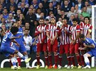 Willian z Chelsea zkouí vyzrát na brankáe Atlétika Madrid z pímého kopu. Ze