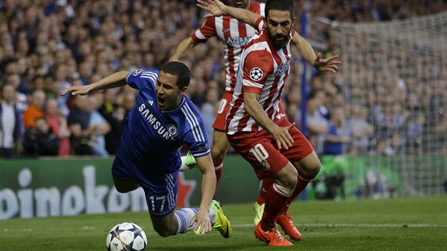 Belgický záloník Eden Hazard z Chelsea padá po zákroku Ardy Turana z Atlétika...