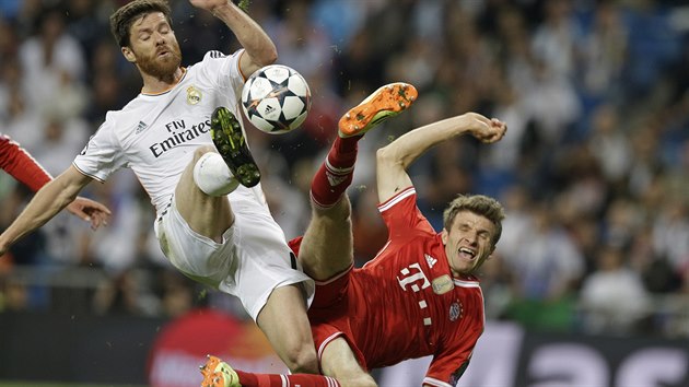 Xavi Alonso z Realu Madrid (vlevo) a Thomas Mller z Bayernu Mnichov bojuj o m.
