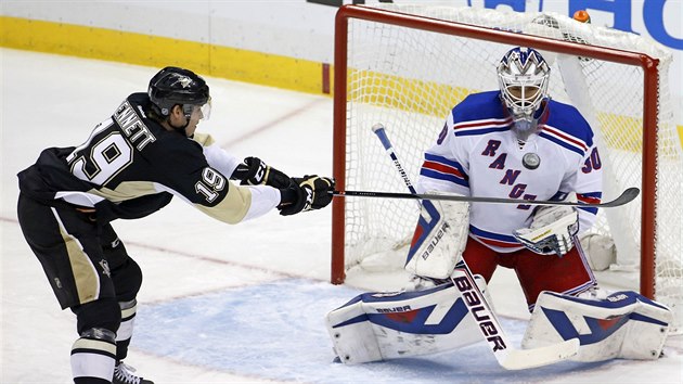 Beau Bennett (vlevo) z Pittsburghu usmruje puk na branku Henrika Lundqvista v brance NY Rangers.