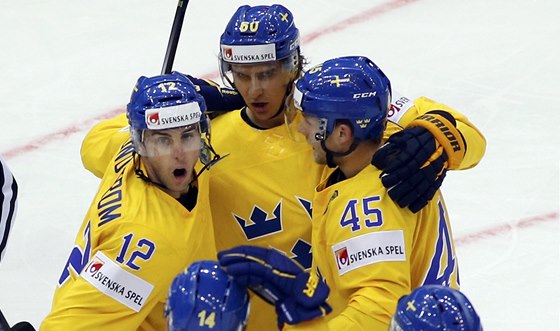 PRVNÍ GÓL. védtí hokejisté se radují z trefy Mikaela Backlunda (uprosted) v
