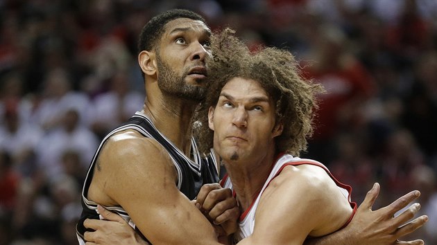 Tim Duncan (vlevo) ze San Antonia a Robin Lopez z Portlandu v podkoovm souboji o doskok.