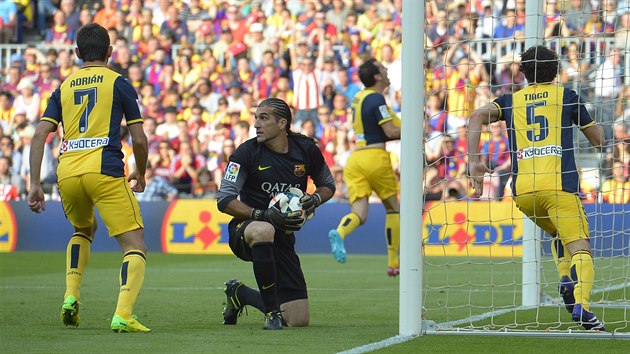 NA KOLENOU. Glman Barcelony Jose Manuel Pinto (v ernm) se smutn rozhl pot, co se prosadil Diego Godn z Atltica Madrid (v pozad uprosted).