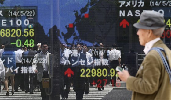 Japonec prochází kolem elektronické tabule, která ukazuje pohyb akcií na...