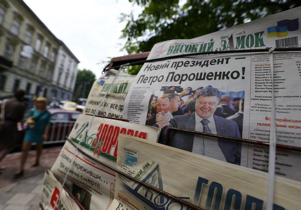 "Nový prezident - Petro Poroenko!" stojí na titulní stránce ukrajnských novin...