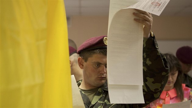 Ukrajinsk vojk zkoum hlasovac lstek ve volebn mstnosti v Kyjev (25. kvtna 2014).