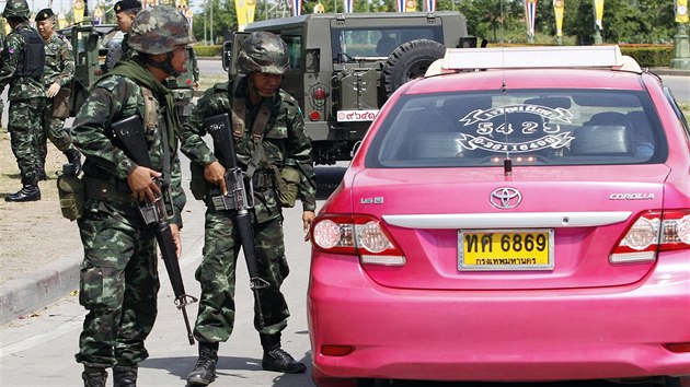 Thajt vojci kontroluj taxky blzko msta, kde se konala demonstrace provldnch "ervench trik" (Bangkok, 20. kvtna 2014).