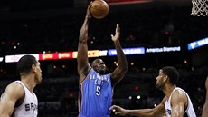 Kendrick Perkins z týmu Oklahoma City zakonuje pes Tima Duncana (vpravo) ze...