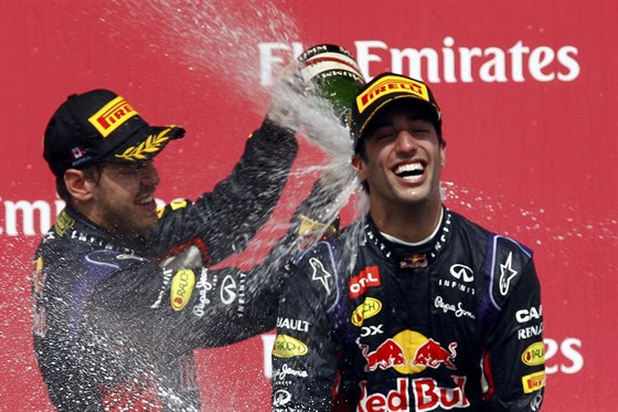 DEN PRO RED BULL. Sebastian Vettel poutí umivé víno za krk Daniela Ricciarda,...