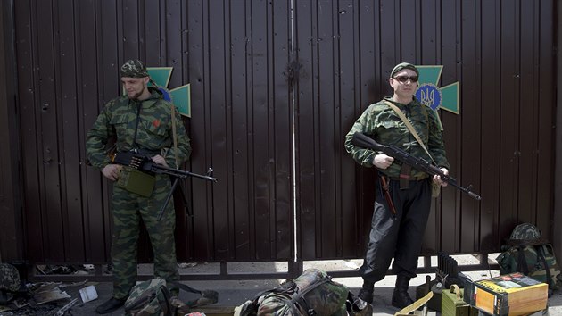 Prorut rebelov se zbranni stoj ped vstupem do zkladny ukrajinsk hranin stre, kterou obsadili po tkch bojch (4. ervna 2014).