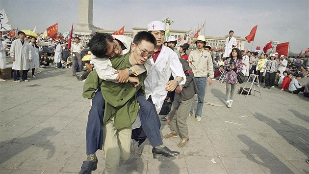 Kdy komunistick reim na jae 1989 odmtl s demonstranty diskutovat, zahjili mnoz studenti hladovku. Fotografie zachycuje zdravotnka nesoucho studenta, kter po tech dnech hladu zkolaboval.