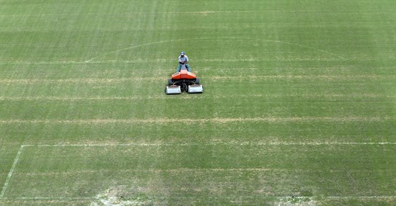 Správce hit na stadionu v Manausu upravuje trávník ped úvodním zápasem...