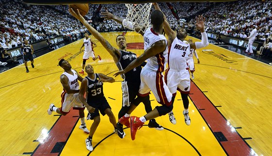 Letící Chris Bosh z Miami se snaí zblokovat  Dannyho Greena ze San Antonia. 