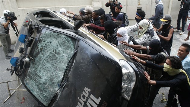 Demonstranti demoluj policejn vz v Belo Horozinte bhem mistrovstv svta 2014.