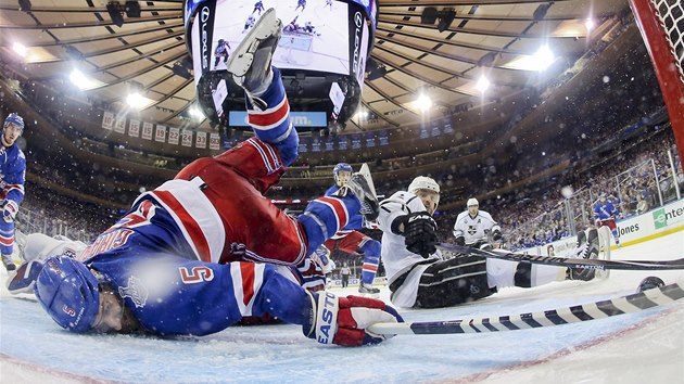 TVRD PISTN. Dan Girardi z New York Rangers se vlee sna pomoci svmu branki Henriku Lundqvistovi a zastavit puk ped brankovou rou, sedc Marin Gbork z Los Angeles oima tla puk za branku.